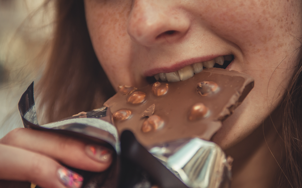 Close up of a girl eating chocolate.