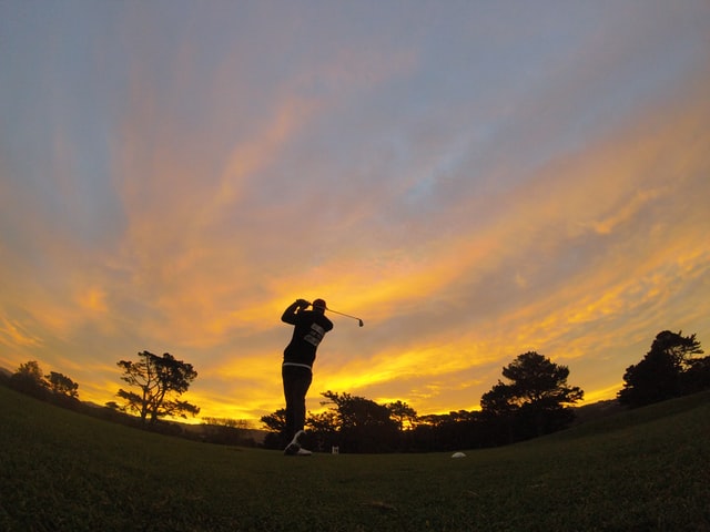 Someone golfing at sunset.