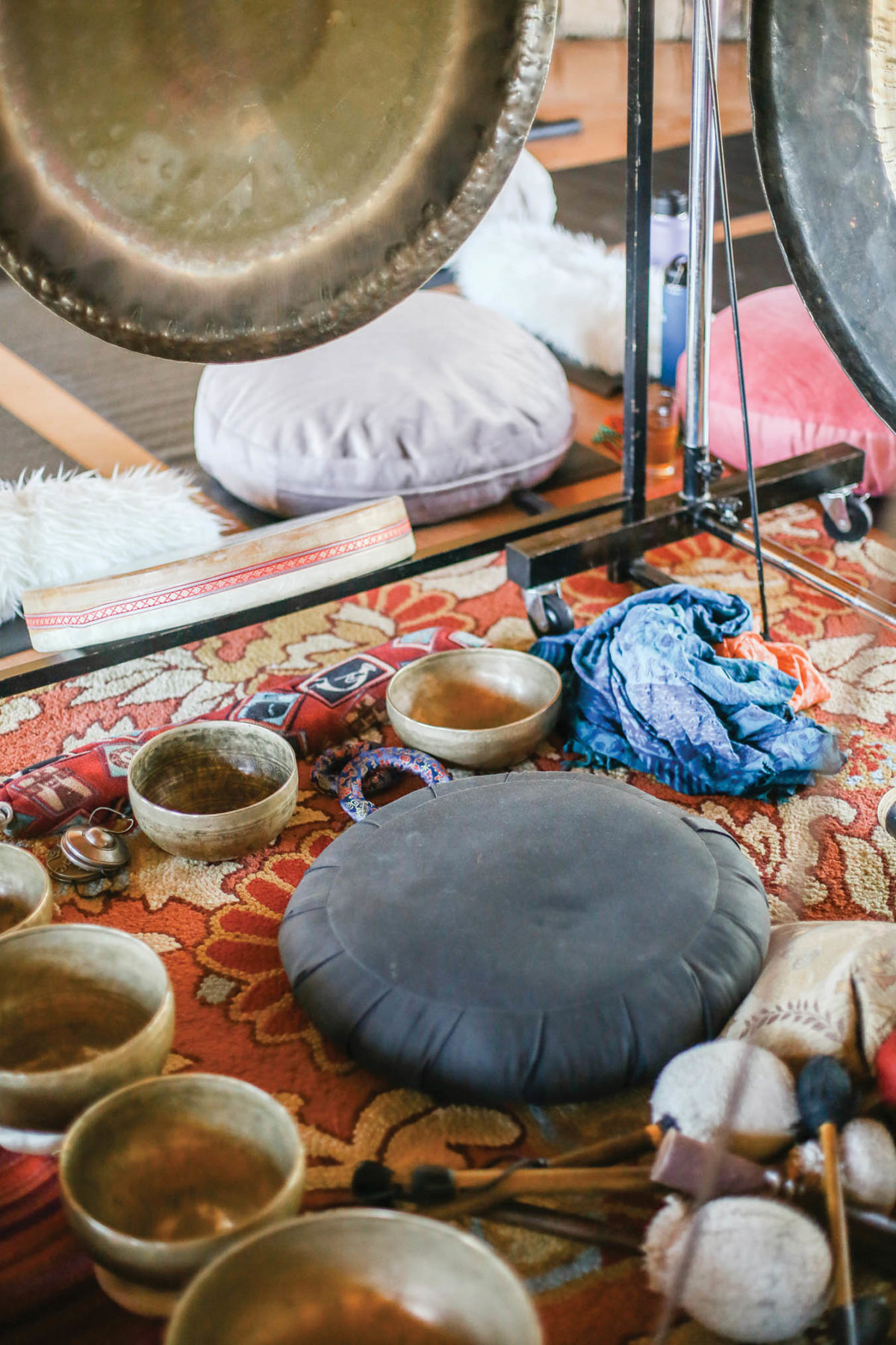 A sound bath setup with pillows, blankets and bowls.