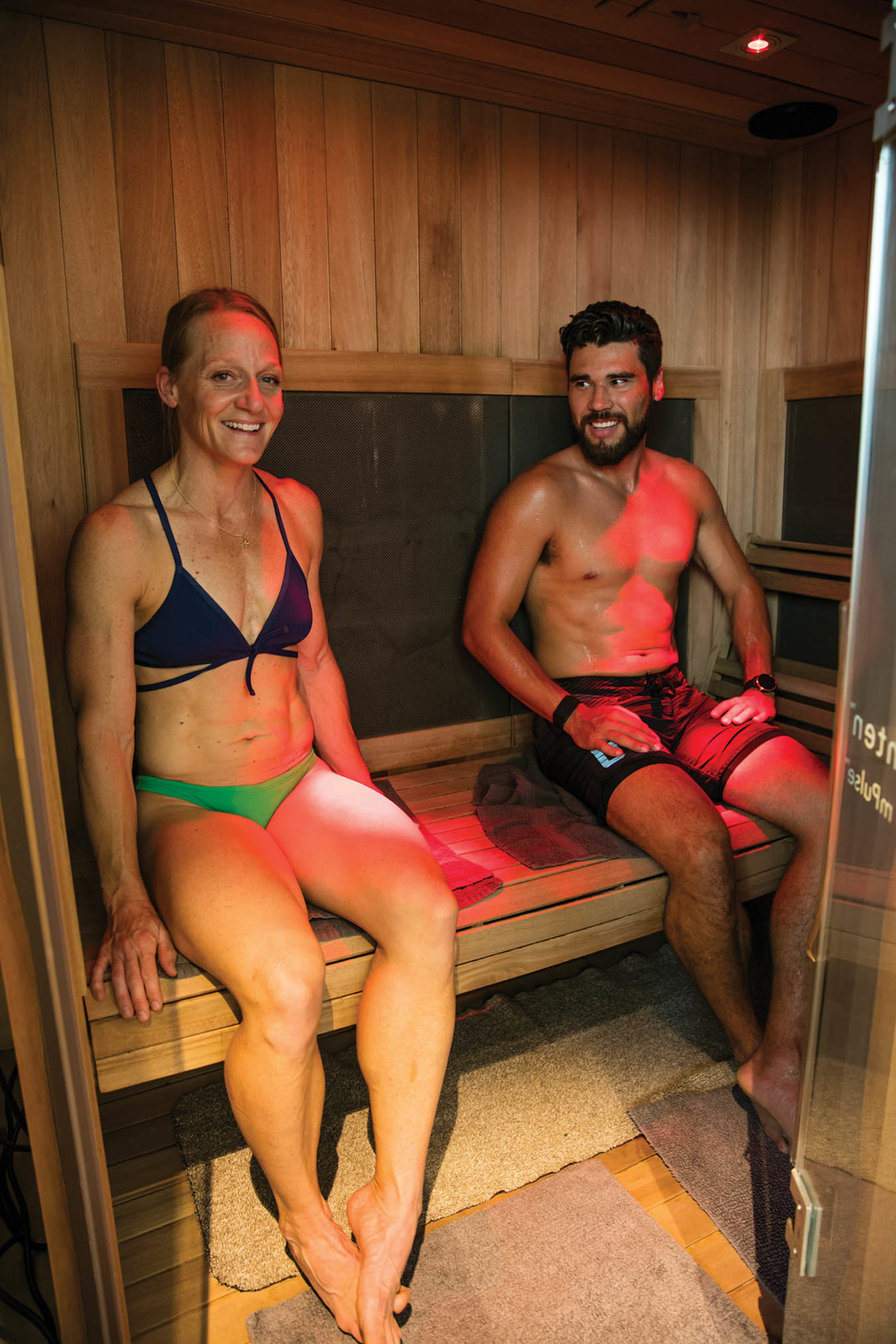 A man and woman sitting in a sauna.