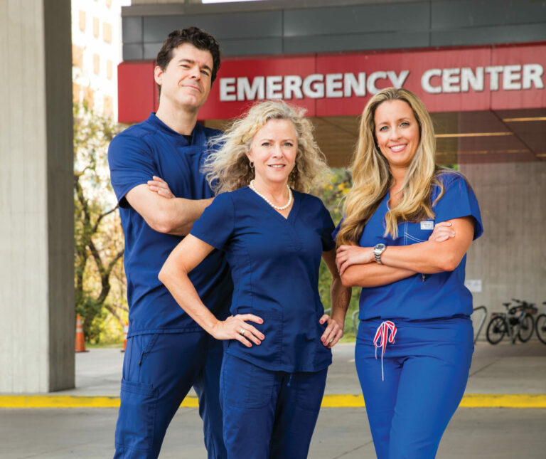 Fernando, Nancy and Tracie posing in front of a hospital.