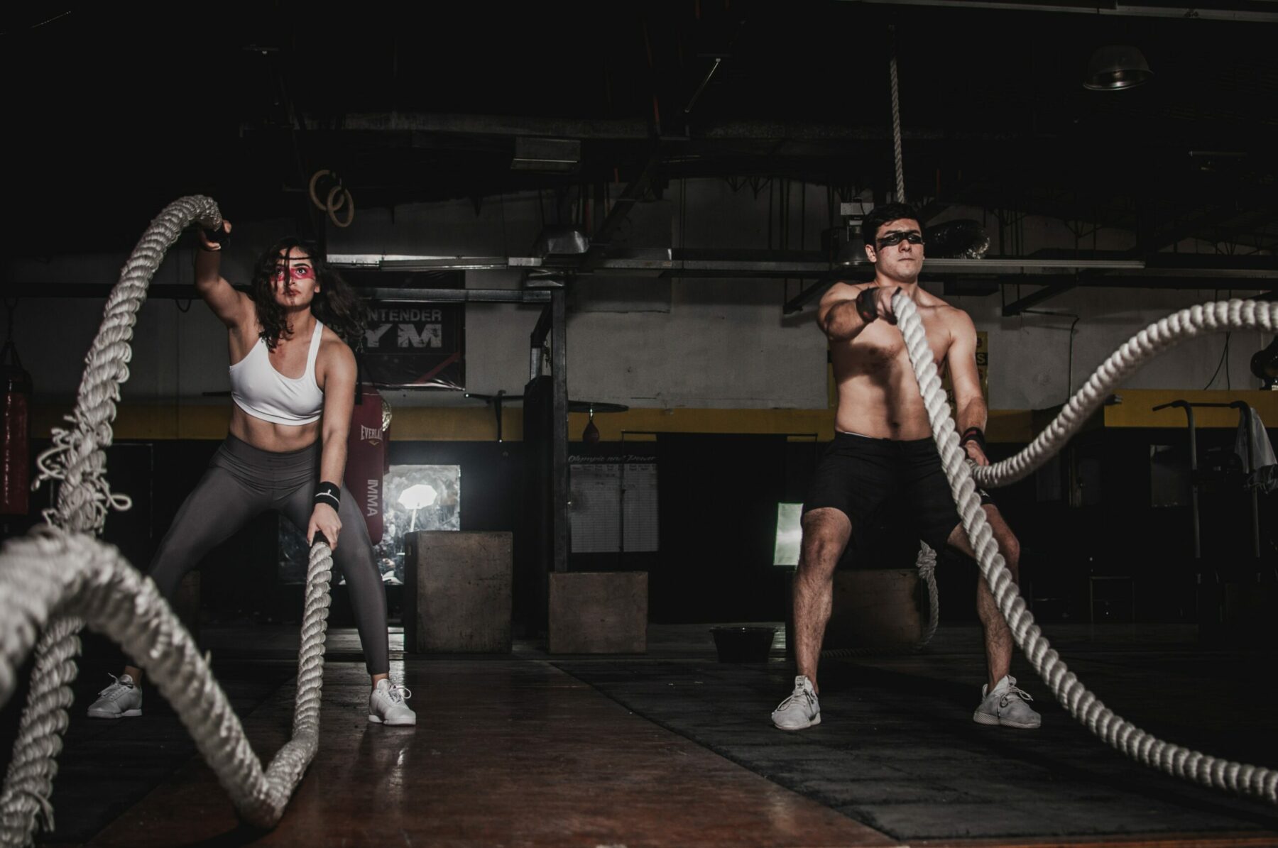 Man and woman using battle ropes.