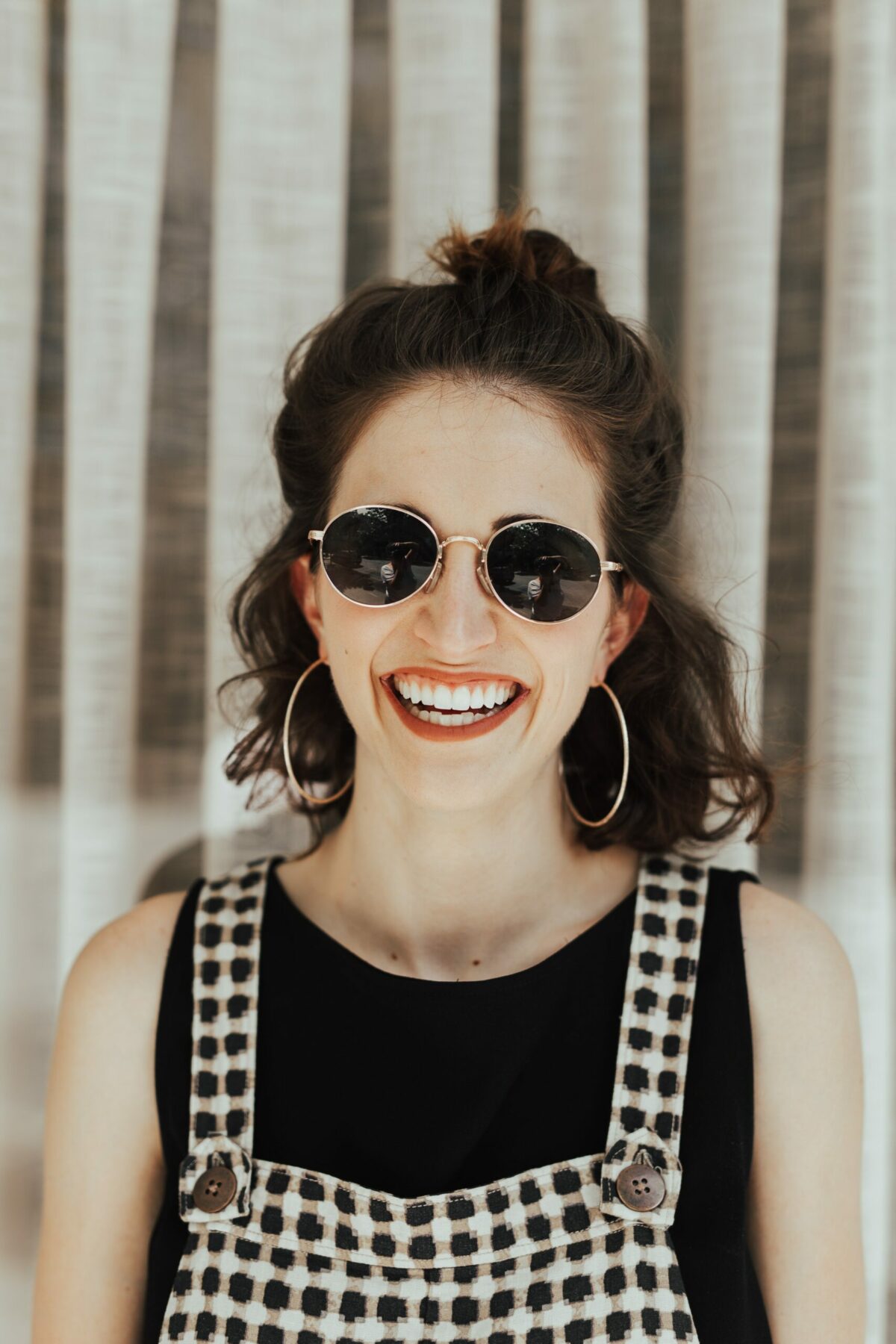 Woman with sunglasses smiling.