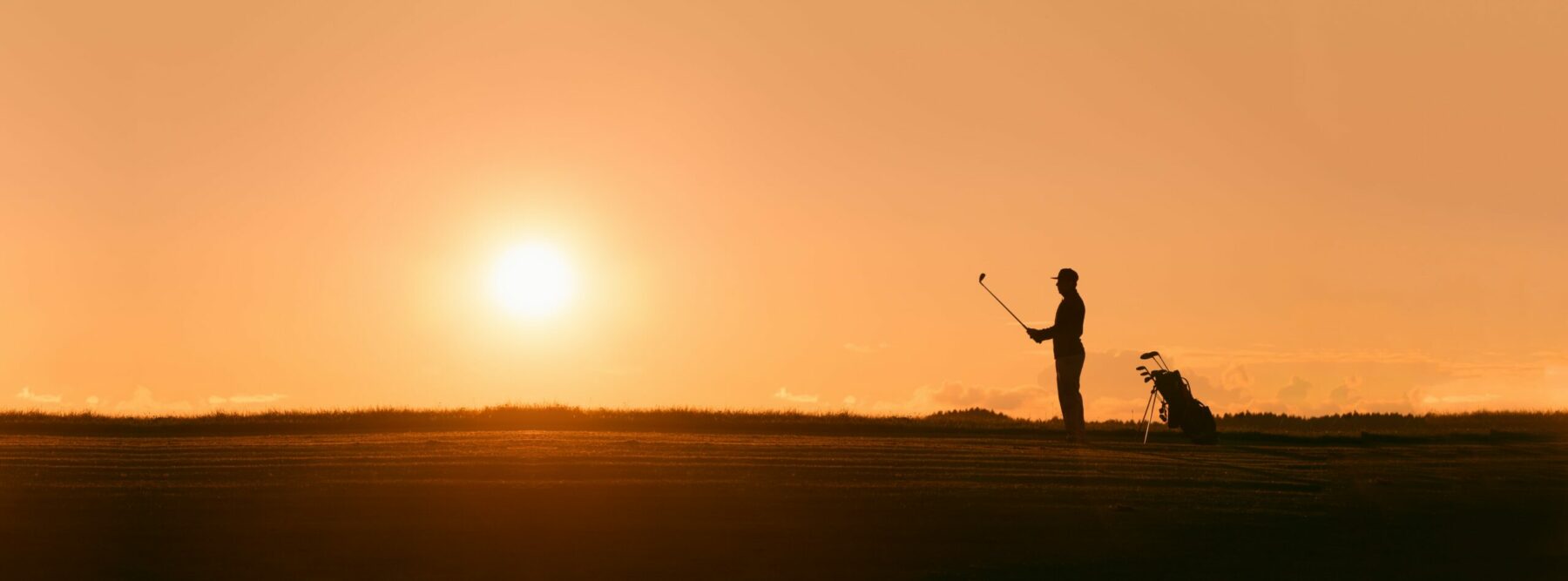 Someone playing golf at sunset.