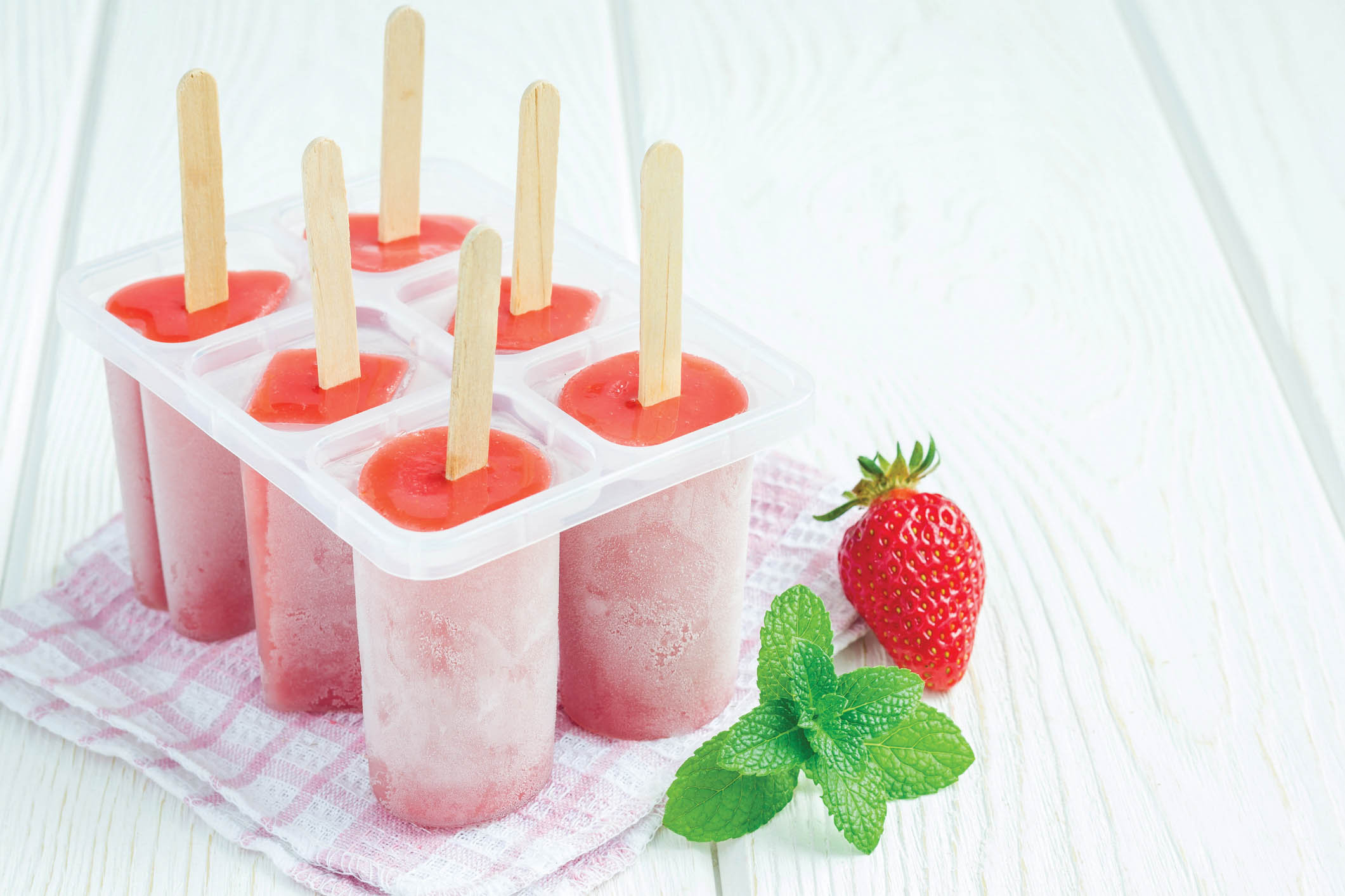 Homemade popsicles with strawberry and banana, copy space.