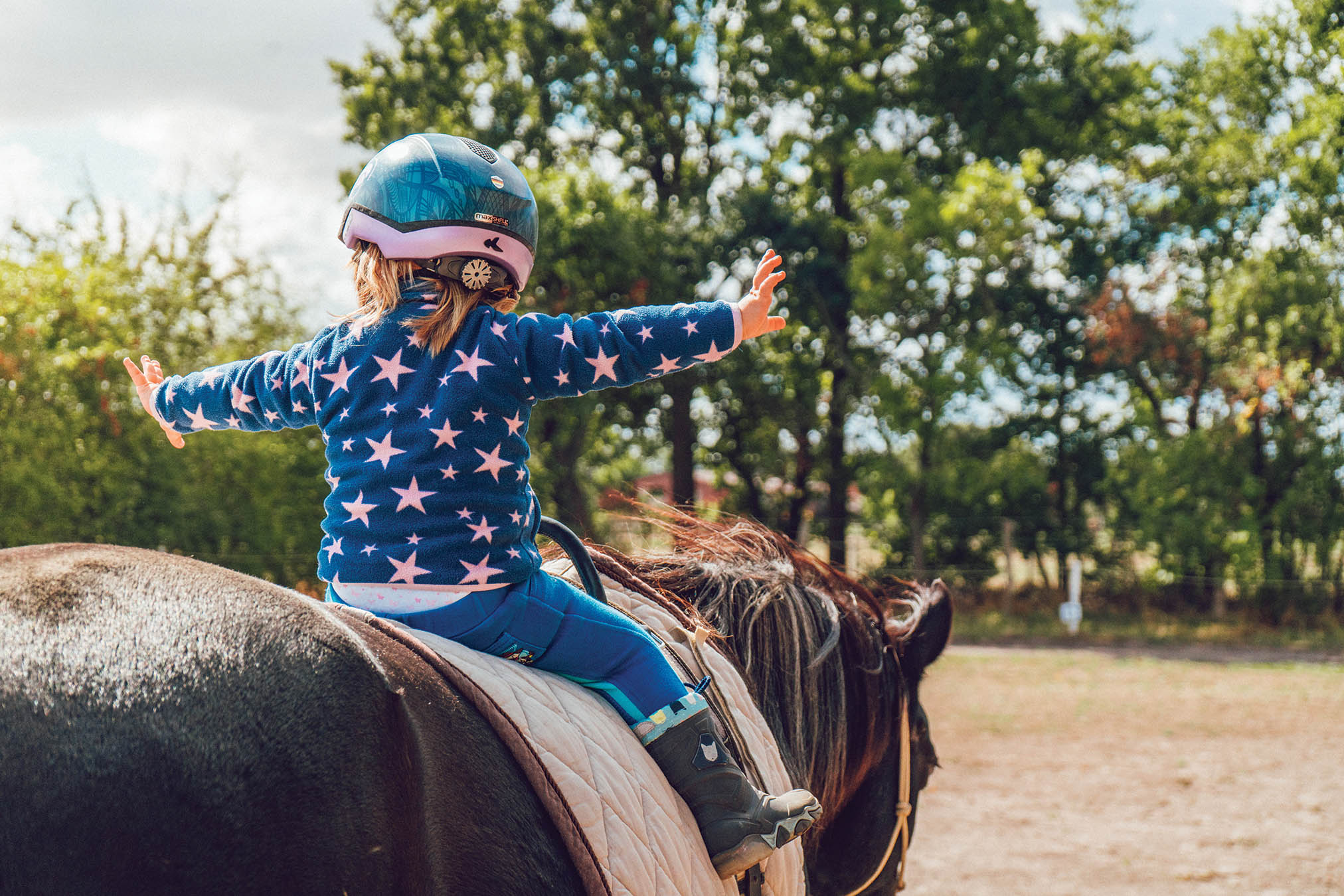Little girl riding a horse.