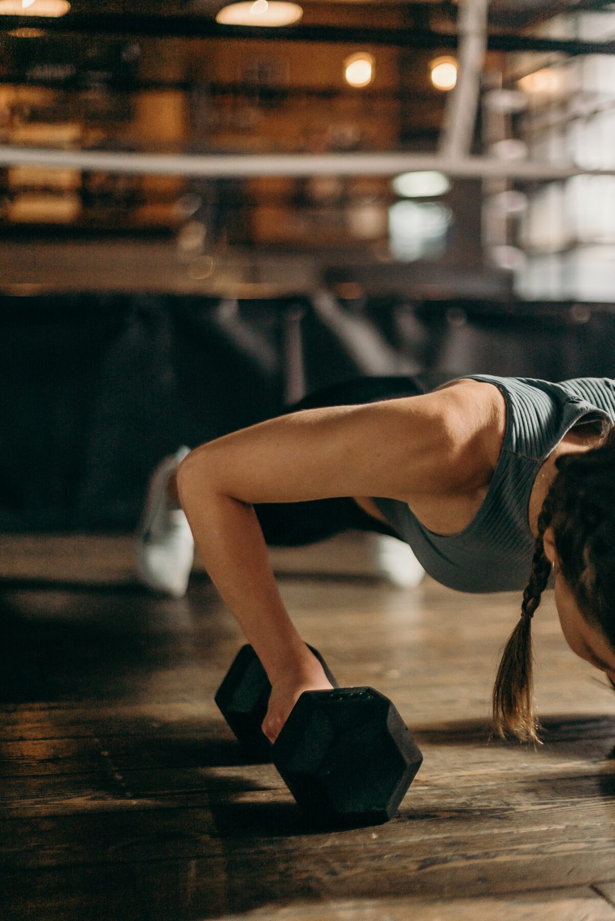 Woman doing pushup with dumbbells.